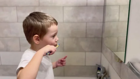 Child brushing teeth in bathroom close-up Stock Footage 296923286