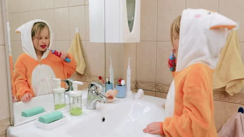 Child brushing teeth in a bathroom Stock Footage 146453185