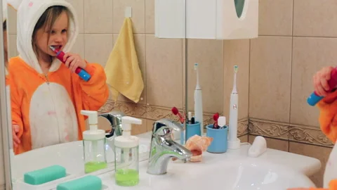 Child brushing teeth in a bathroom Stock Footage 146601528