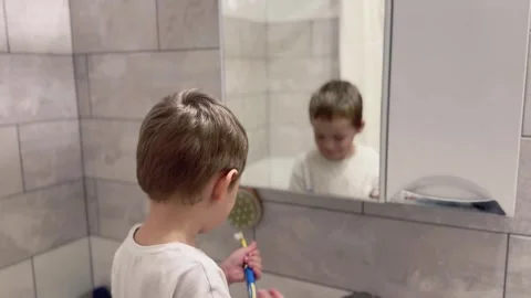 Child brushing teeth in bathroom, view from behind Stock Footage 296923333