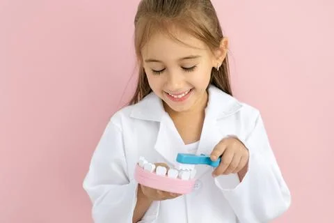 Child brushing teeth model during International Dentist Day Stock Photos