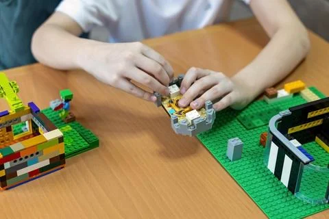 Child building creative brick structures on table. Close up of a childs hands Stock Photos