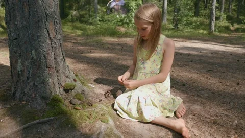Child building a miniature forest setup at the base of a tree Stock-Footage 293572154
