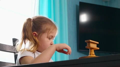 Child is building towers and patterns with wooden cubes at a table Stock Footage 320333964