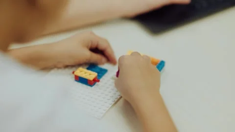 Child builds with colorful blocks at a table in a classroom Video stock 345602570