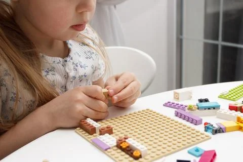 Child builds with constructor bricks, plays with toys Stock Photos