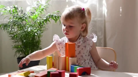 A child builds a tower of colored cubes. Stock Footage 194584519