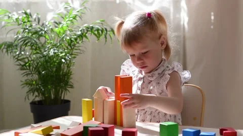 A child builds a tower of colored cubes. Stock Footage 195099442