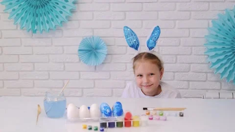 A child with bunny ears is looking for candy on an Easter egg hunt Stock Footage 233179741