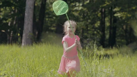 Child with a butterfly net running on a forest glade 스톡 동영상 89985412