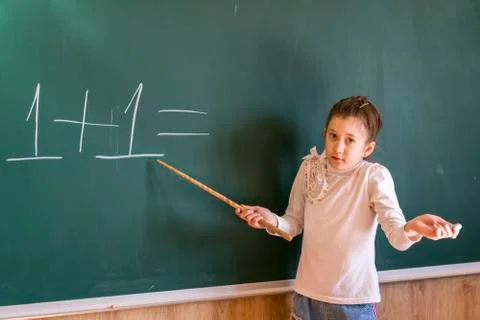 The child can not solve the problem in the school near the board. A hard day  Stock Photos