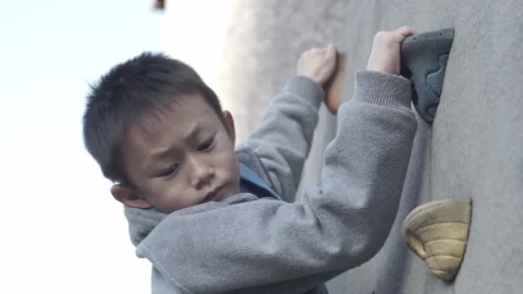 Child carefully climbing down a wall Stock Footage 220581434