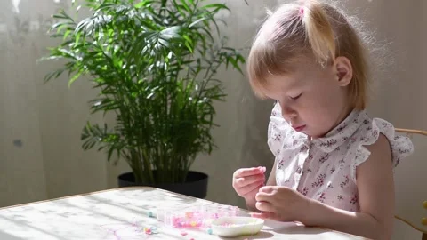 The child carefully collects the beads. Stock Footage 195099484