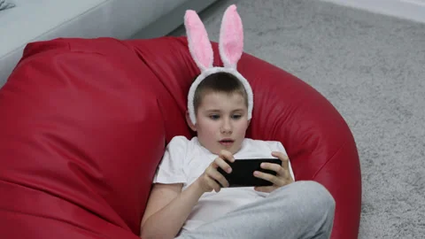 Child celebrate Easter at home using mobile cell phone Stock Footage 180374185