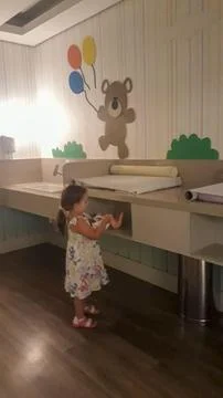 Child on changing table decorated with teddy bear Stock Photos