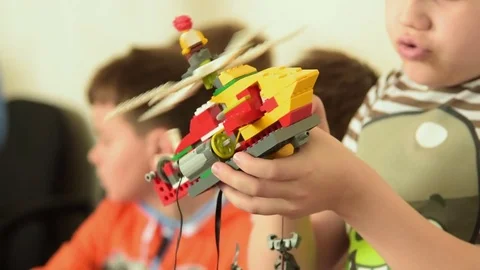 Child checking work of his LEGO helicopter robot, Russia Stock Footage 79988895