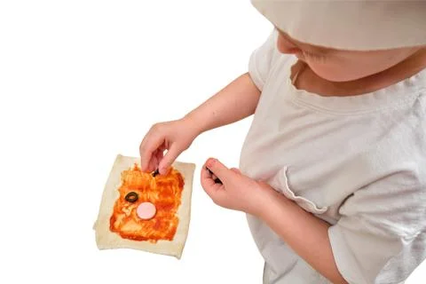 Child chef preparing small pizza on white isolated background. Little boy pla Stock Photos