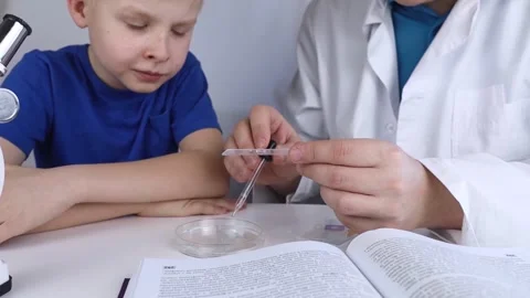 Child chemist. Teacher shows a visual experiment. A science mentor teaches an ex Stock Footage 267009750