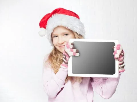 Child in christmas hat with tablet Stock Photos