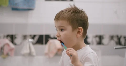 The child cleans his teeth in front of a mirror Vidéo 123983915