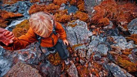 Child climbing over rocks in the Pyrenees during a family hike Stock Footage 303636449