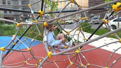 A child climbs up an alpine grid at courtyard of city residential building Stock Footage 244949095