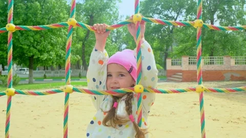 A child climbs up an alpine grid in a park on a playground on summer day. childr Stock Footage 278052853