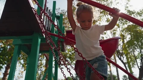 A child climbs a grid in a park on a playground on a hot summer day. Rope slide Stock Footage 255073744