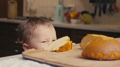 Child climbs on stool, trying to reach things on the kitchen's table. Stock Footage 165307030