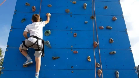 Child climbs on wall with protective ropes Video stock 76275854