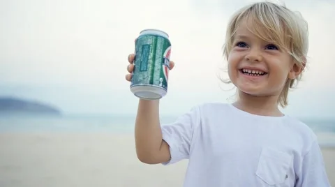 Child clinking a can of beer and drinking for fun on beach party in slow motion. Stock Footage 56067183