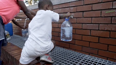 Child collect water during drought in Cape Town, South Africa Stock Footage