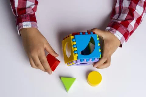 The child collects the cube sorter constructor. Puzzle cube sorter, an early  Stock Photos