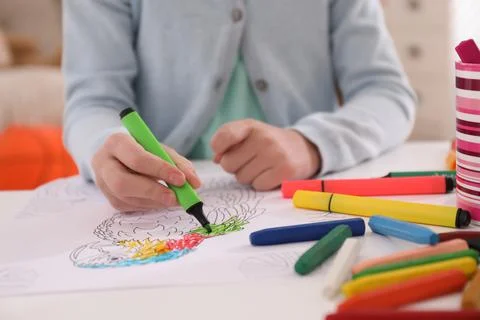 Child coloring drawing at table in room, closeup Foto stock