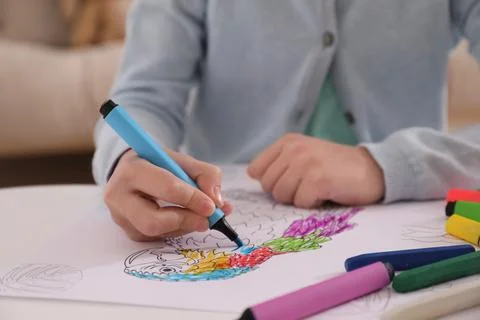Child coloring drawing at table in room, closeup Foto stock