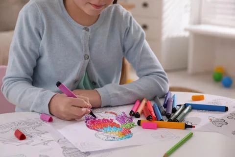 Child coloring drawing at table in room, closeup Foto stock