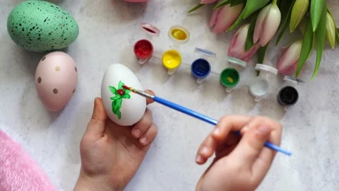 Child coloring the Easter egg , wooden table with tulips Stock Footage 265423623