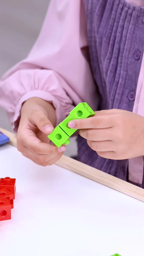 Child Connecting Green Math Manipulative Cubes for Educational Counting Activity Stock Footage 325700998