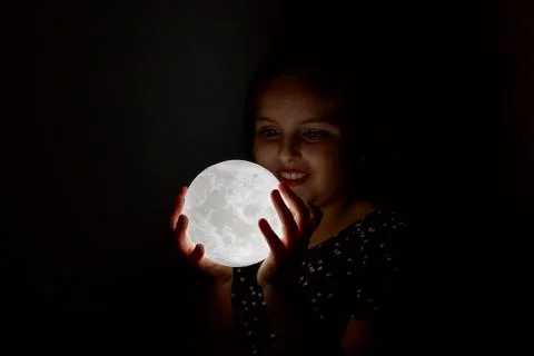 Child contemplating the moon in hands Stock-Fotos