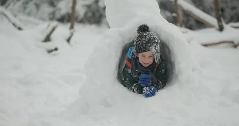 Child crawling through snow tunnel Video stock 333926299