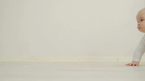 The child crawls on the floor looking at the camera Stock-Footage 88269508