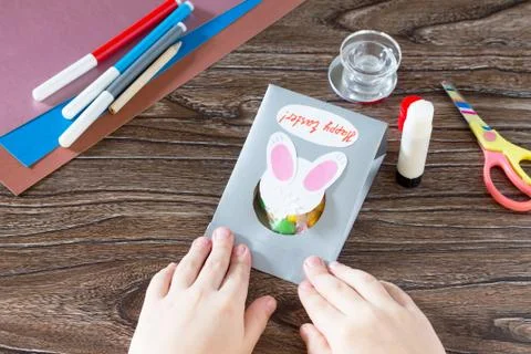 The child create Easter greeting card packaging paper Easter bunny candy. Stock-Fotos