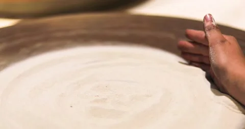 Child creates a sand pattern on a potter's wheel with the back of his hand.  Video stock 199652411