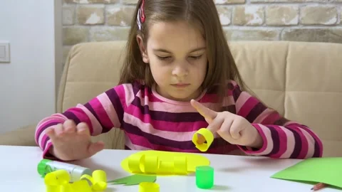 Child creating an applique with colored paper and glue. Concept of hobby Stock Footage 255193333