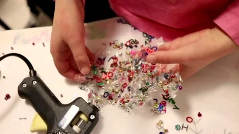 Child creating glue and sequin crafts in creative mess Stock Footage 196241571