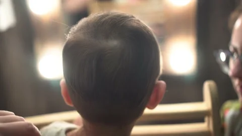 The child is cut in front of a mirror from the back of the head. One year old Stock Footage 236475696