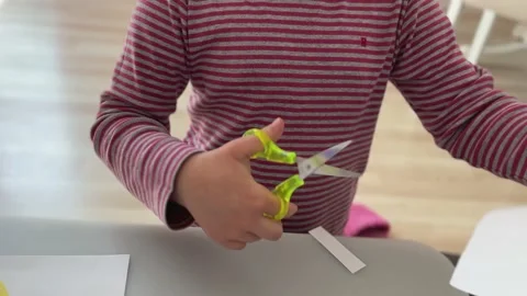 A child cuts paper with scissors. Children's creativity, psychology, fantasy Stock Footage 238513434