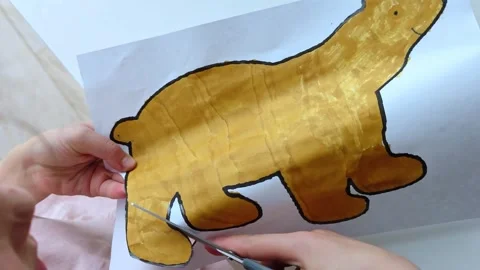 The child cuts paper with scissors at the table. Children's creativity. Stock Footage 309085500