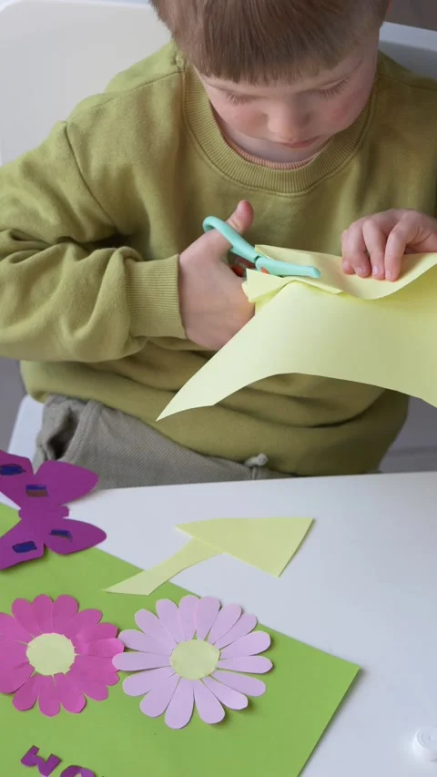 Child cutting paper elements for mothers day card using scissors. Creative Video stock 330973258