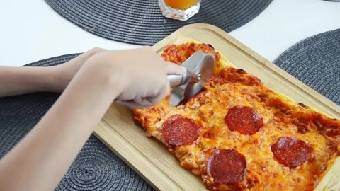Child cutting pepperoni pizza slice with pizza cutter close up 스톡 동영상 338094212
